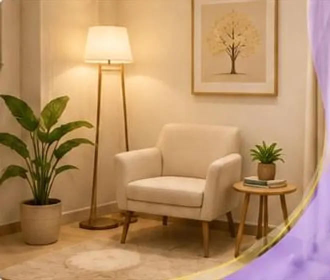 Sala de atendimento com poltrona clara, luminária de pé, planta e quadro de árvore amarela na parede